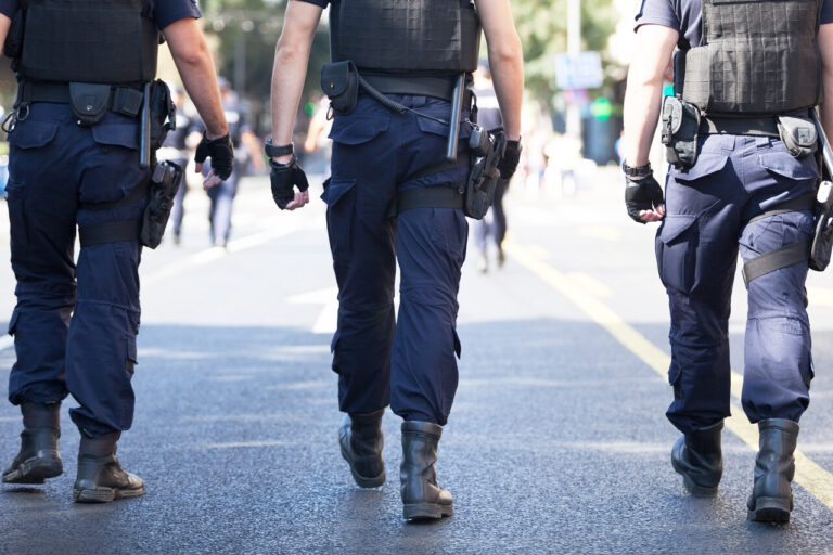 Group of police officers walking on a street, representing cases handled by California police brutality lawyers.